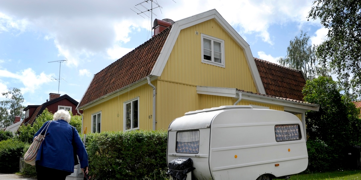 Äldre person utanför en gul villa. Många pensionärer överväger att sälja sin bostad när den blivit för stor. Arkivbild.