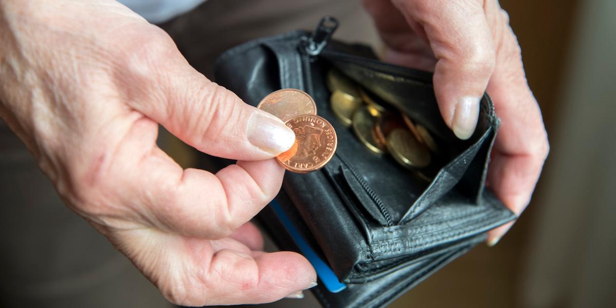 Pensionär med plånbok och mynt. Inkomstpensionstillägg är ett tillägg till den allmänna pensionen som ska hjälpa pensionärer med låg pension, men de som har allt för låg pension kan inte få det